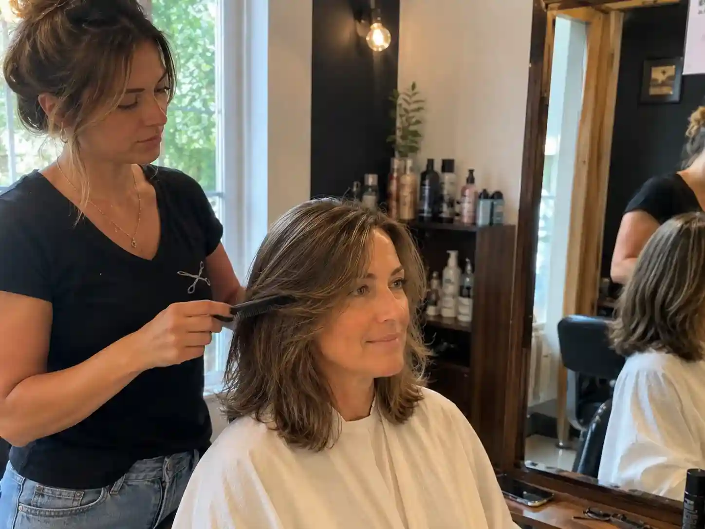 Friseurin kämmt schulterlanges Haar einer Kundin im Salon während der Typberatung für die passende Frisur - Frisuren Schulterlang