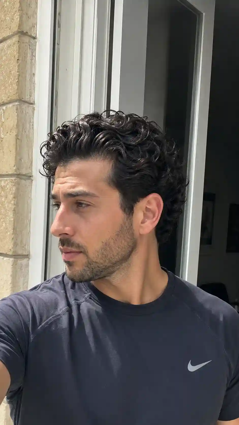 Bro Flow Frisur zeigt mittellange Wellen, eine beliebte Wahl für Männer mit Locken im lässigen Stil