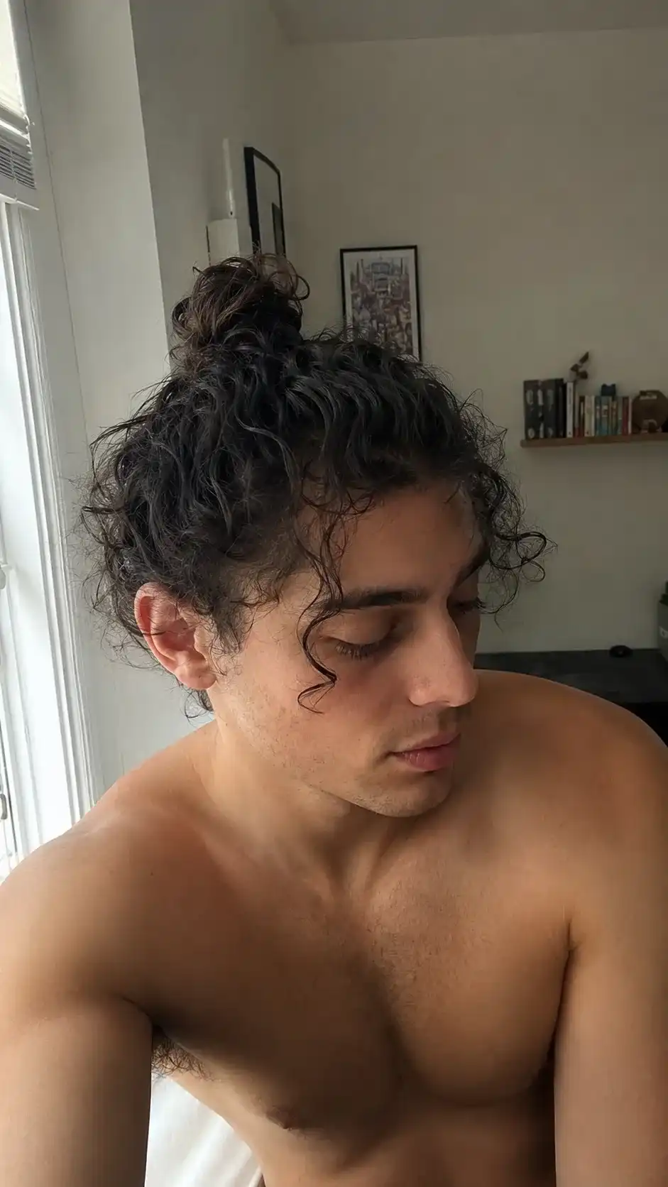 Man Bun mit Locken bindet langes lockiges Haar zusammen, praktisch für aktive Männer mit Locken