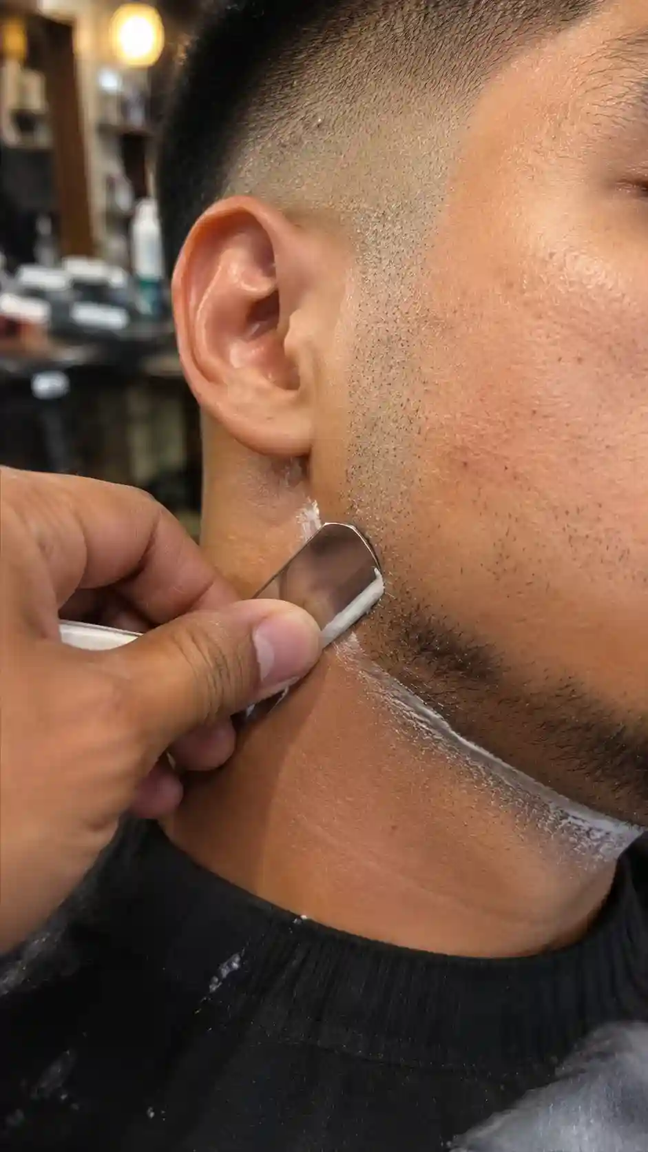 Barbier zieht die Nackenlinie mit dem Rasiermesser sauber nach