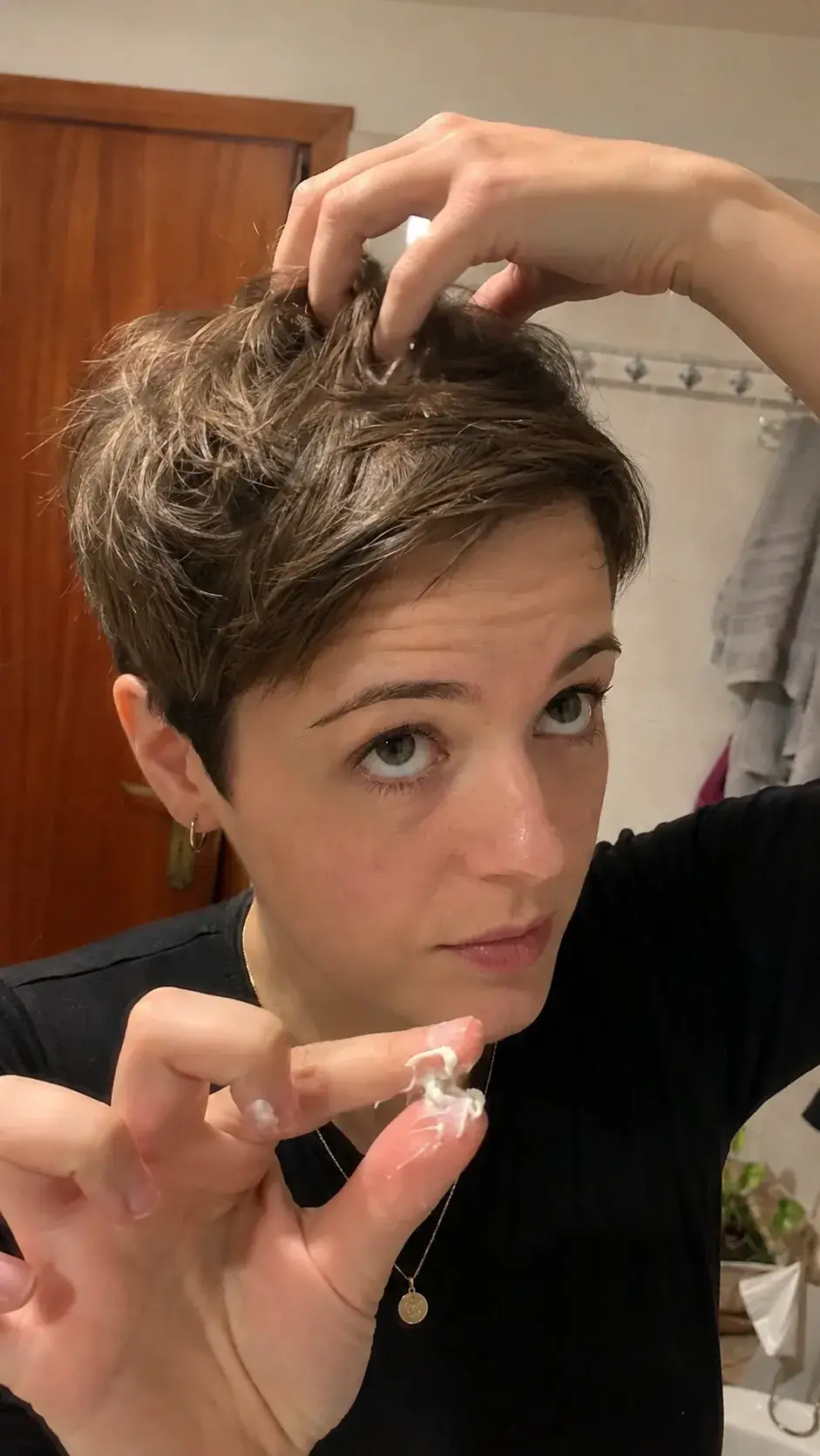 Frau stylt ihren Pixie Cut mit Wachs zwischen den Fingerspitzen - Kurze Haare Stylen