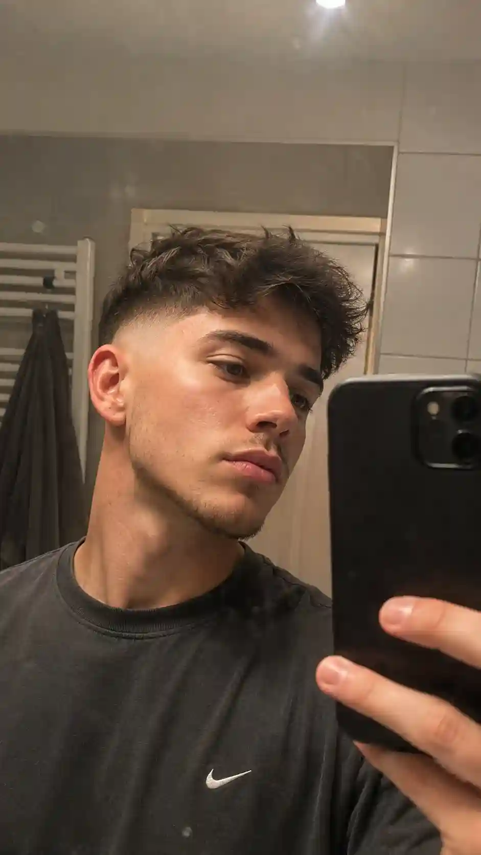 Junger Mann mit moderne Frisuren Männer und Fade im Spiegel