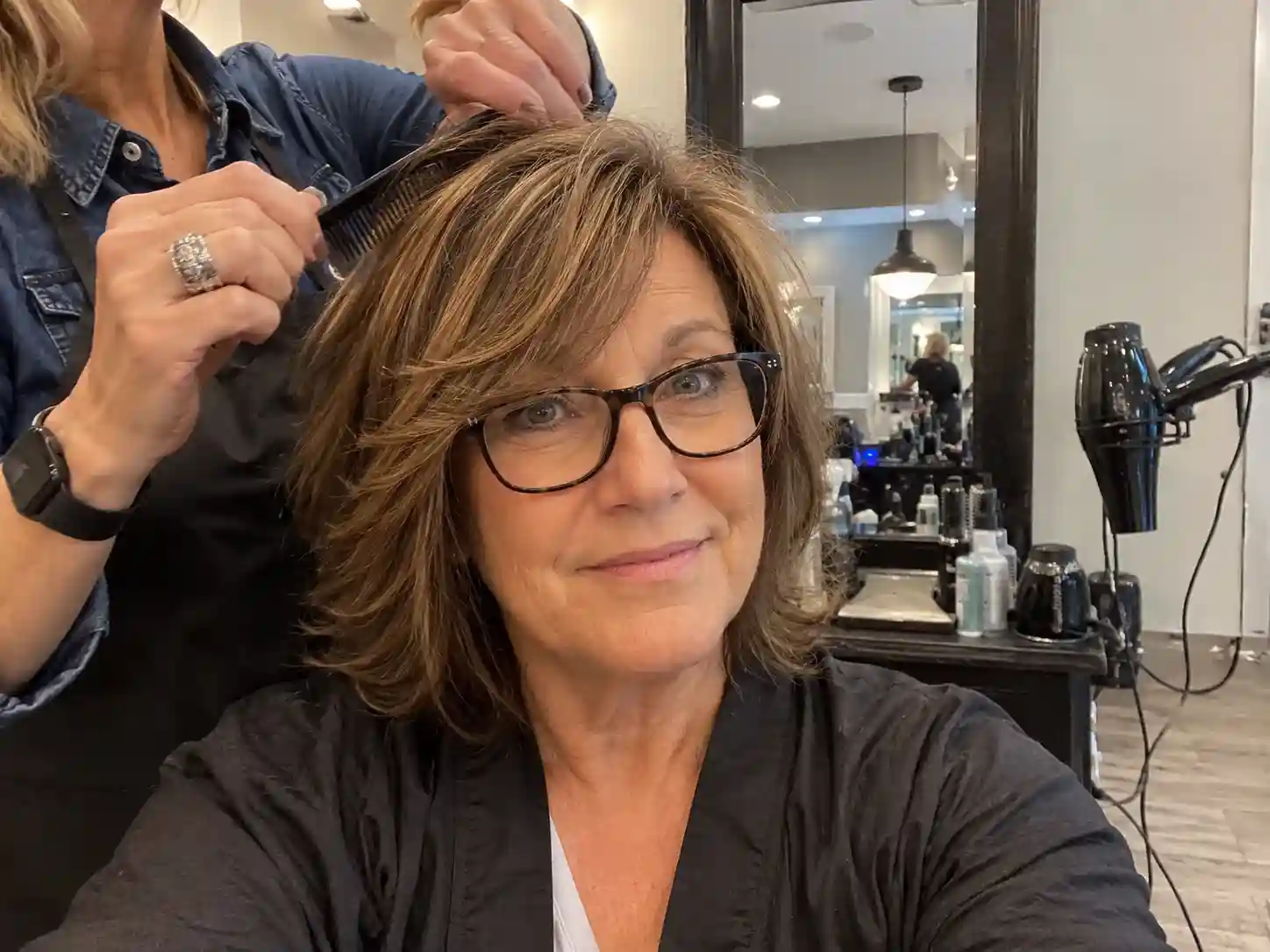 Seitlicher Fransen-Pony mit Brille beim Friseur zeigt aktuelle Frisuren ab 60 die jünger machen mit Brille