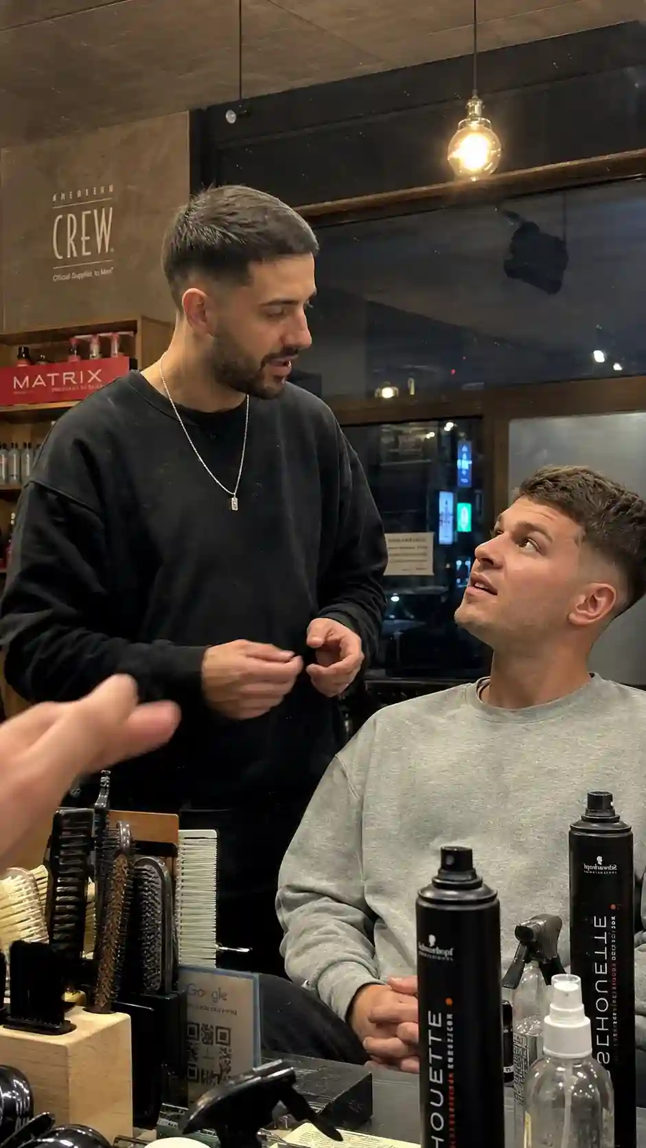 Friseur bespricht mit einem Kunden im Salon den passenden kurzen Haarschnitt - Männer Frisuren kurz