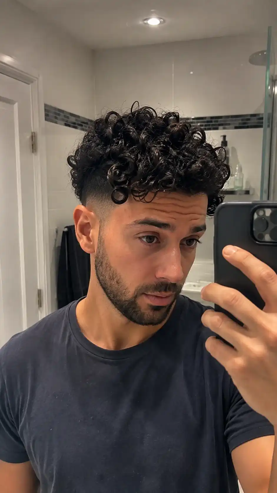 Undercut mit Locken zeigt kurze Seiten und definierte Locken oben, ideal für Männer mit Locken im Alltag