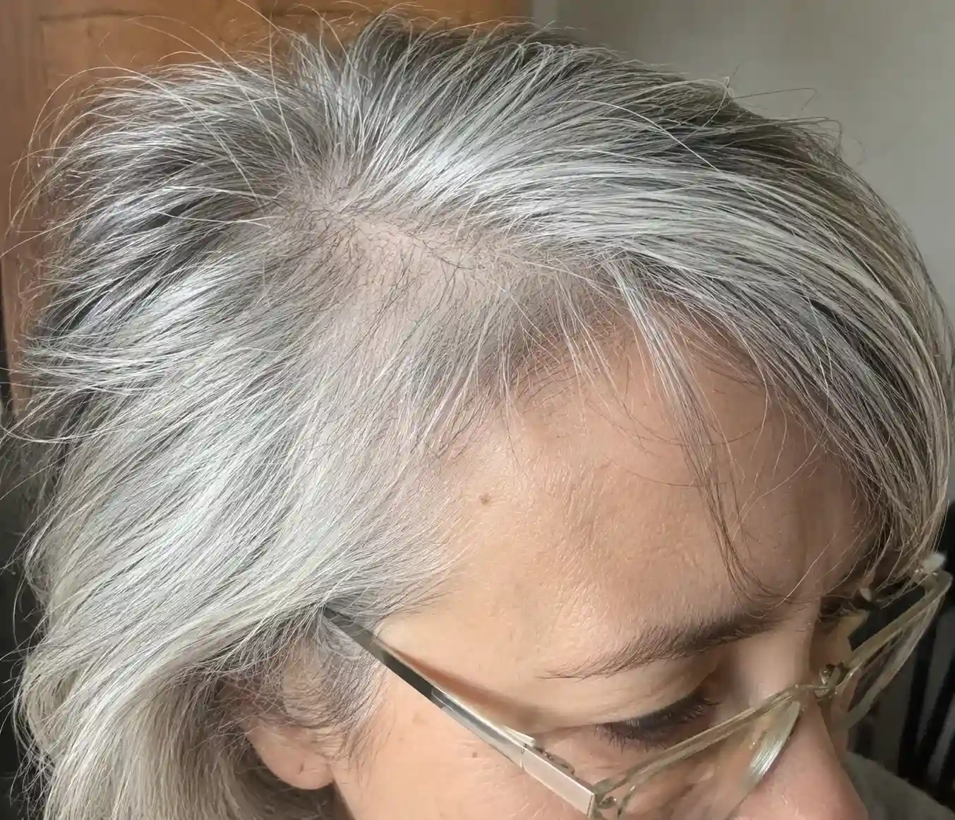 Nahaufnahme von feinem Haar mit Volumen am Ansatz und Brille bei Frisuren ab 60 die jünger machen mit Brille