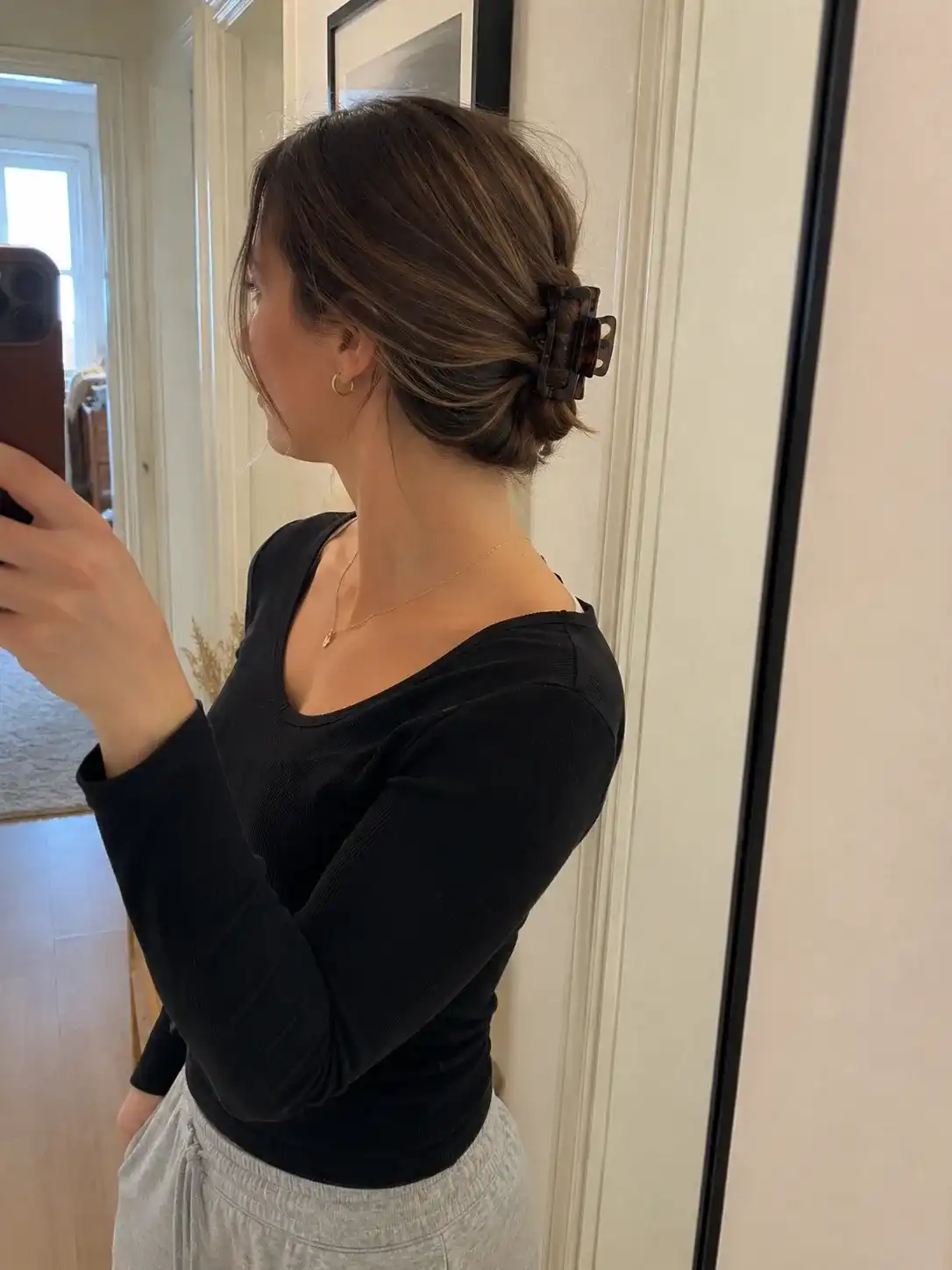 Alltagstaugliche Frisur mit Haarklammer als tiefer Zopf mit Twist im Flurspiegel fotografiert am Morgen